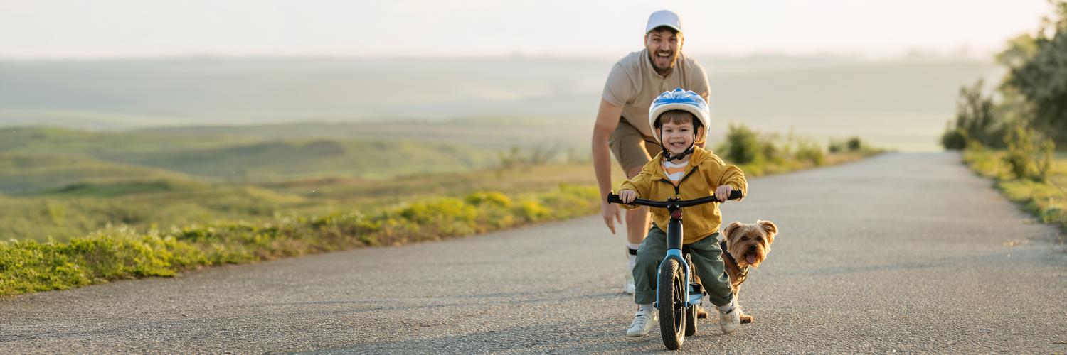 man teaching a boy how to ride a bike
